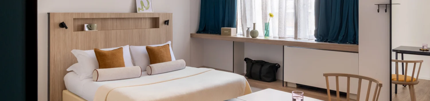 Modern room with double bed, table and wide window for business and leisure stays - Aparthotel Colombo, BZAR hotels in Rome